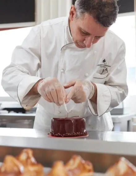 Chef Laurent Bernard finishing a chocolate cake